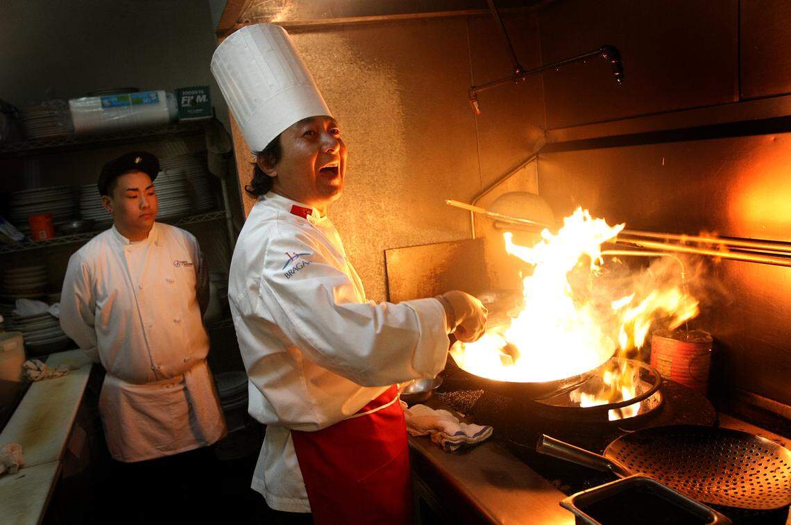 Chef Zhongyi Liu kicks up some flames as he prepares a dish served at a banquet at Fresno’s Hunan Chinese Restaurant in this file photo from 2008.