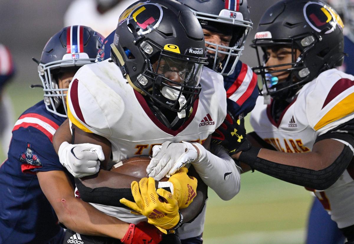 Tulare Union’s Brayden Stevenson, center, is tackled by Garza’s Isaiah Hernandez, left, and Johnny Gardner, right, Thursday, Sept. 7, 2023 in Fresno. Tulare led Garza 35-28 at halftime.