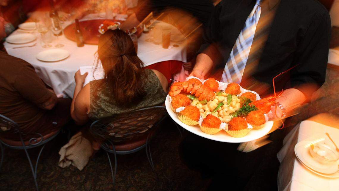 Server Martin Yueng of the Hunan Restaurant carries a dish of Mother and Child Shrimp including deep fried soup-burst shrimp balls and stir fry lobster with macadamia nuts in this Fresno Bee file photo from 2008