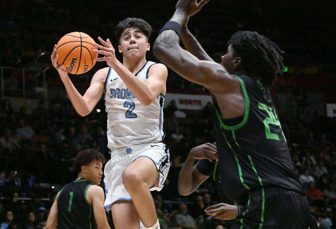 Clovis North’s Elias Gish, left, goes up against St. Joseph’s Tounde Yessoufou, right, in the Central Section Division I basketball championship Saturday, Feb. 24, 2024 at Selland Arena in Fresno.