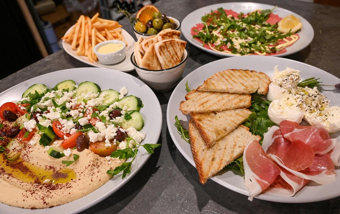 Various sharable plates including beef carpaccio, fries with housemade aioli, citrus marinated olives, loaded hummus, burrata and prosciutto to pair with wines at Lune Wine Bar & Eatery in downtown Fresno.
