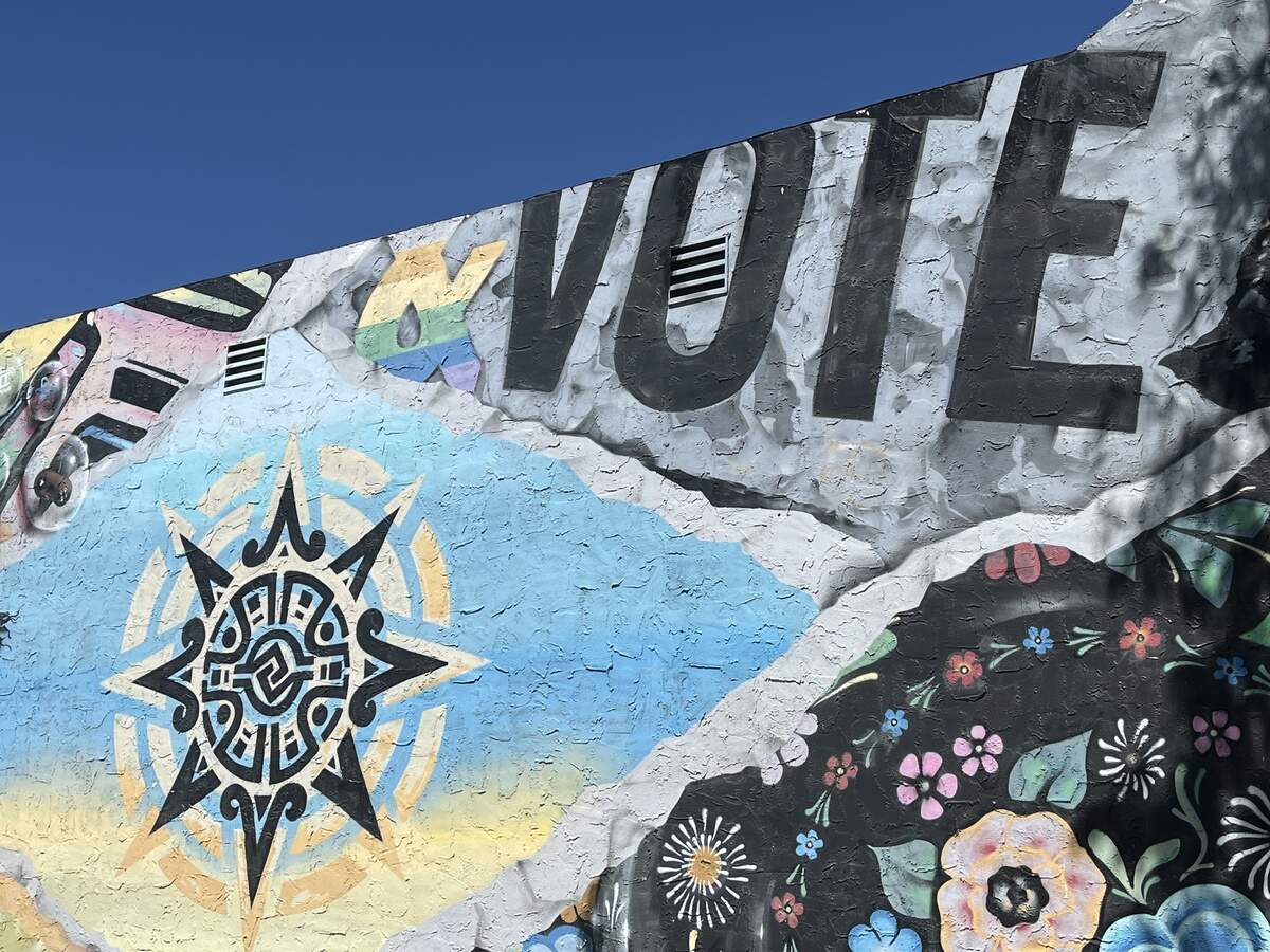 A mural, on the side of a building near the city council meeting, says “Vote.”