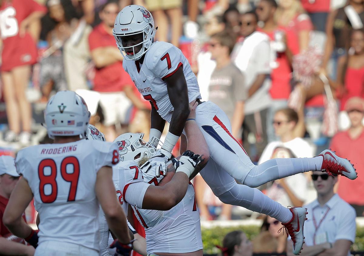 Fresno State wide receiver Derrion Grim is lifted up by Fresno State center Aaron Mitchell after scoring a touchdown last season at Alabama. The Bulldogs after opening the season with a 79-13 rout of Idaho get their first challenge of the season at Minnesota on Saturday, Sept. 8, 2018.