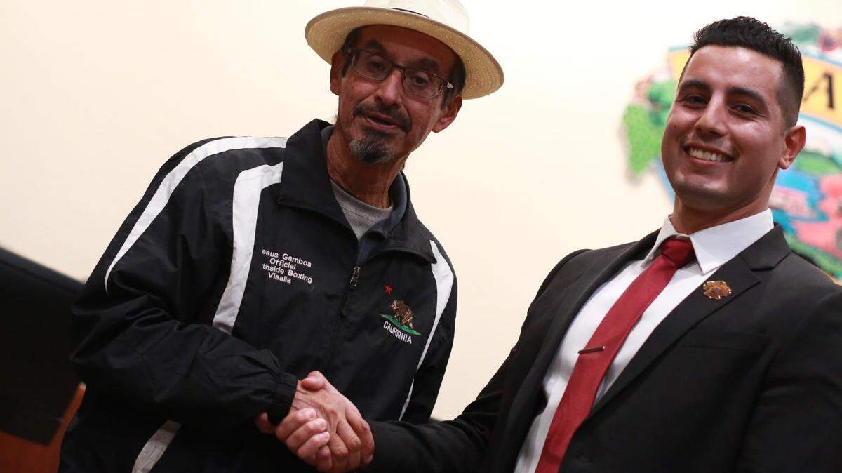 Jesús Gamboa, the first Latino on the Visalia City Council who got elected in 1997 serving 12 years including two terms as mayor and one term as vice mayor (left) shake hands with Visalia’s newly elected city council member Emmanuel Hernández Soto (right) after Soto took oath Wednesday night (Dec. 7) during a special meeting. Soto is the second Latino in the history of Visalia.
