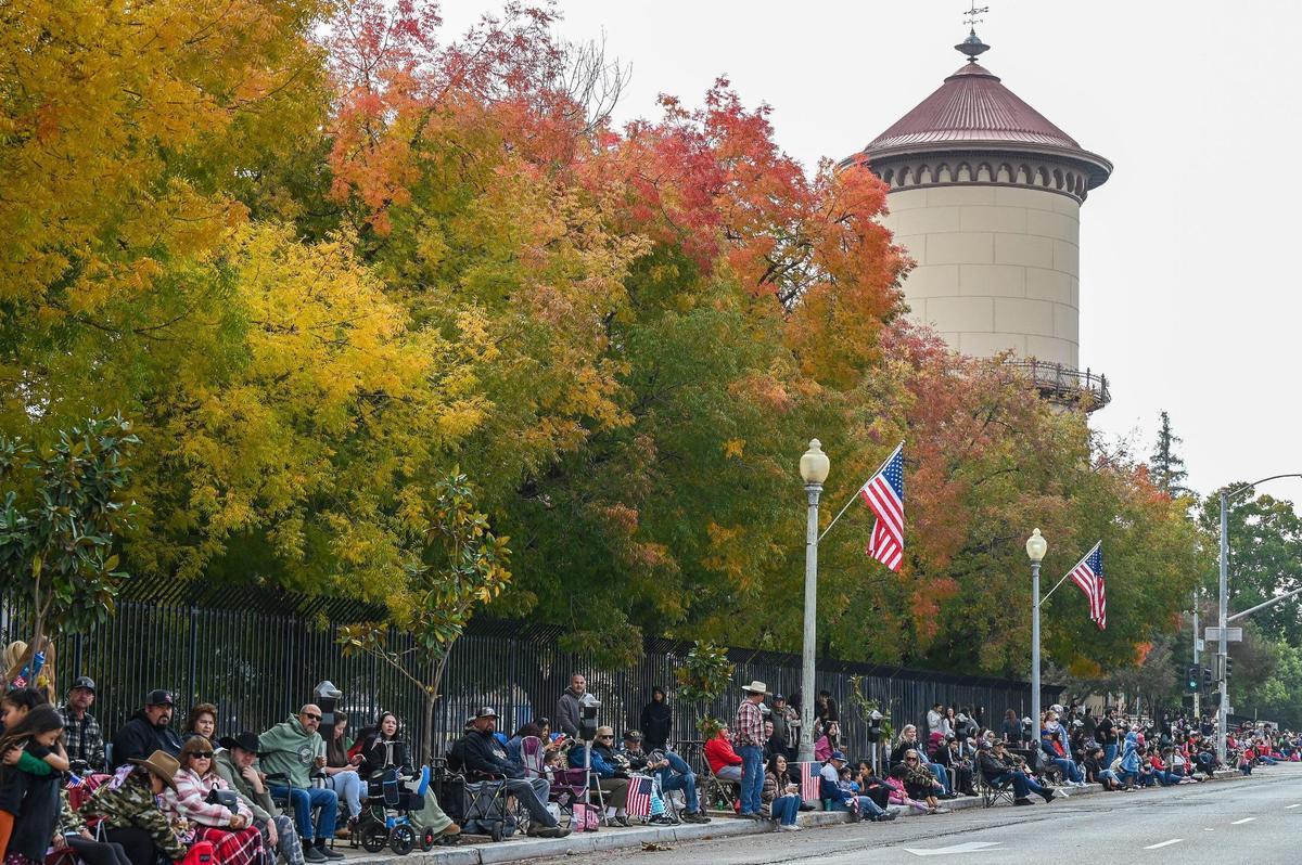 Fall foliage in the trees adds color at the Fresno Water Tower as parade-watchers line Fresno Street to take in the sights and sounds of the 105th annual Central Valley Veterans Day Parade in downtown Fresno on Monday, Nov. 11, 2024.
