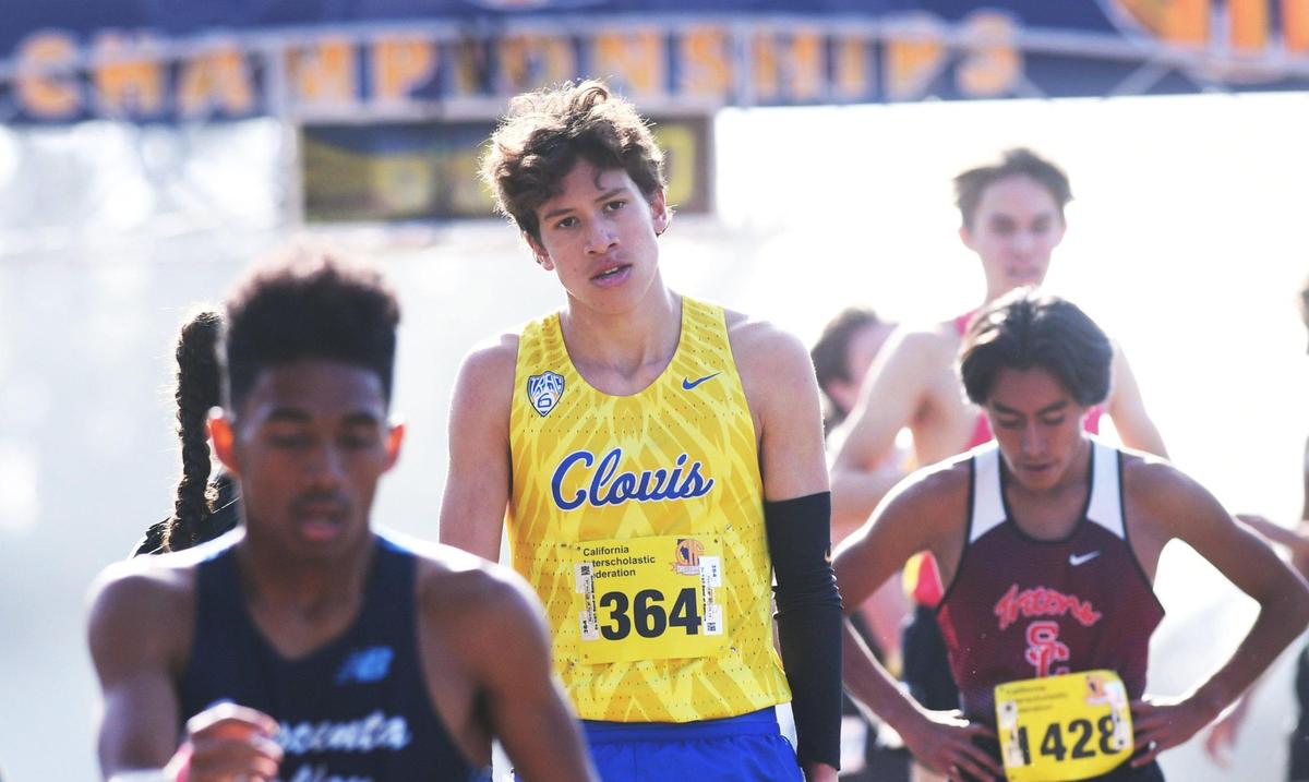 Clovis High’s Christopher Caudillo, second from left, cools down as he walks the chute with other runners after placing second in the CIF Boys D-I state cross country championship Saturday, Nov. 26, 2022 at Woodward Park in Fresno.