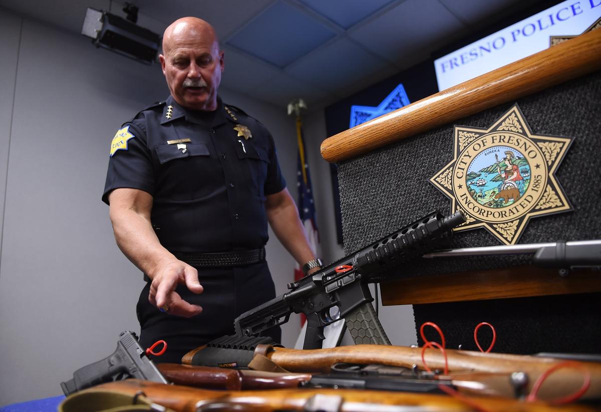 Fresno Police Chief Jerry Dyer displays nine weapons confiscated from the past weekend’s activities during a press conference Tuesday, March 26, 2019 in Fresno. Dyer called most of the activity gang-related, with two of the nine weapons having been converted to fully-automatic fire.