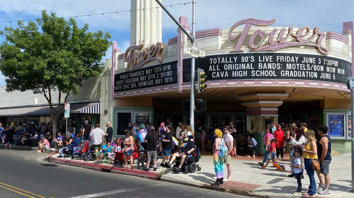 Parade-goers find spots on the Olive Avenue sidewalk in front of the Tower Theatre to watch the 2022 Fresno Pride Parade on Saturday, June 4.