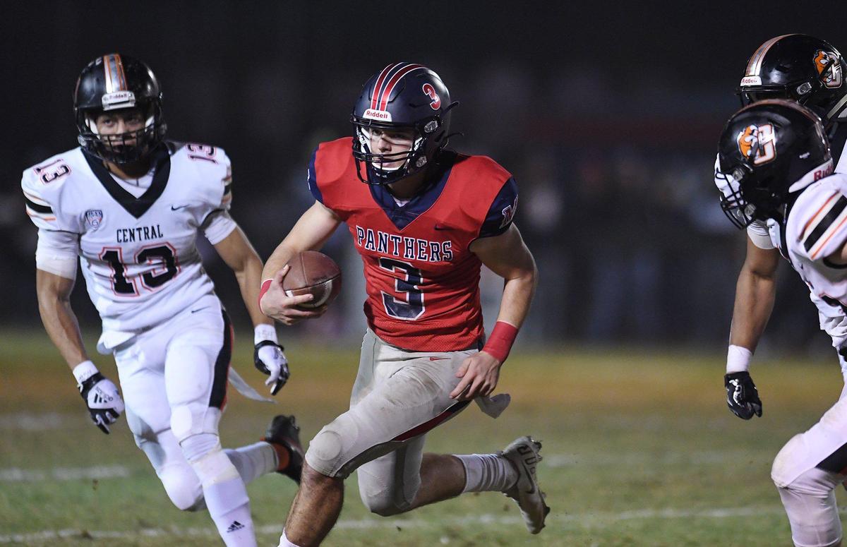 San Joaquin Memorial quarterback Michael Bell, center, scrambles by Central’s defense in a Central Section semifinal game on Friday, Nov. 19, 2021 in Fresno. Central won 37-20.