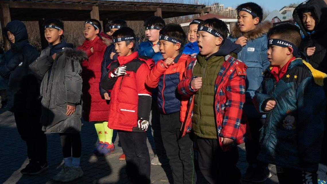 Boys recite a pledge before group activities.