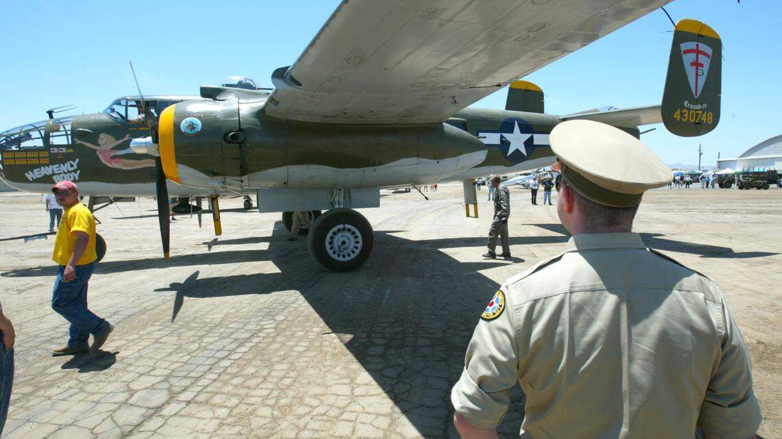 Dressed in a period civilian flight instructor uniform, Chuck Workman of Lakewood, California, at right, watches a B-25 Mitchell bomber that was part of a fly-in at Eagle Field in Dos Palos in June 2007.