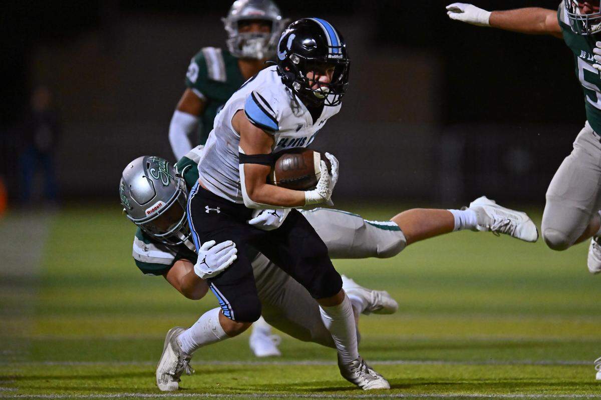 Clovis North’s Andrew Chavez (23) is tackled by De La Salle’s Andrew Cunningham (18) in the third quarter of their NorCal Division I-AA regional championship game at De La Salle High School in Concord, Calif., on Friday, Dec. 1, 2023. De La Salle defeated Clovis North 41-0.
