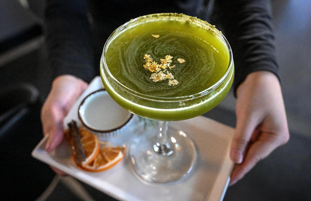 The gyokuru martini comes with jumai sake, blue agave, lime juice, matcha, gold flakes along side a shot of nigori sake at O-iza Japanese Cuisine in the River Park shopping center.