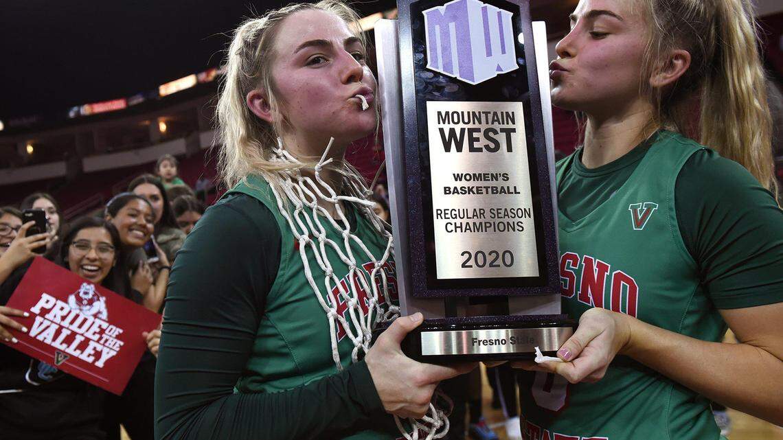 Fresno State freshman guards Haley Cavinder, left, and her sister Hanna Cavinder, right, pose with the Mountain West trophy after defeating San Jose State 78-76 Wednesday, Feb. 12, 2020 in Fresno.