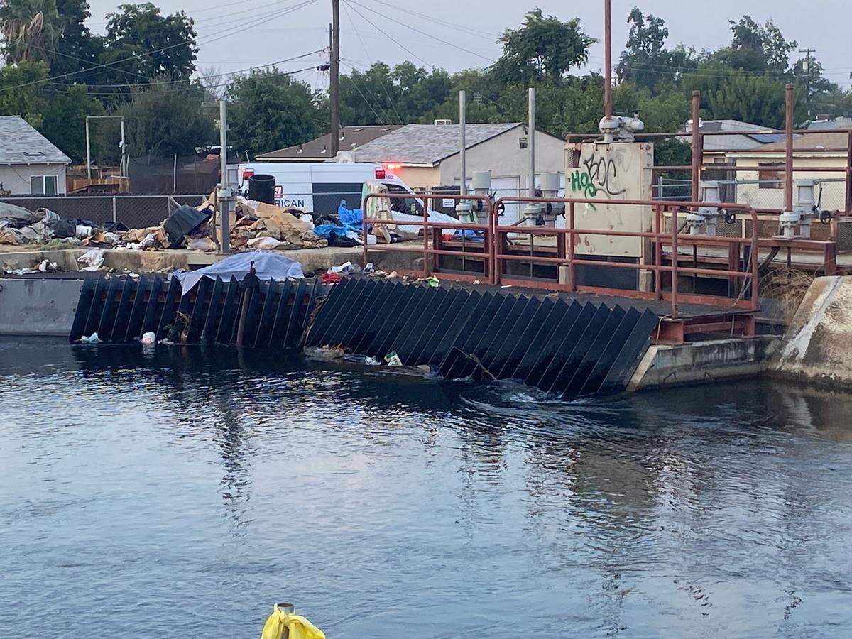 Firefighters look over a canal where a body was discovered about 6:30 a.m. Thursday, Sept. 21, 2023, near Millbrook and McKinley avenues in Fresno.