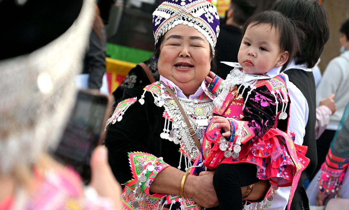 Ia Vang holds her 1-year-old granddaughter Felicity Tha as they pose for photos during opening day of the Hmong New Year celebration at the Fresno Fairgrounds, Thursday morning, December 30, 2021.
