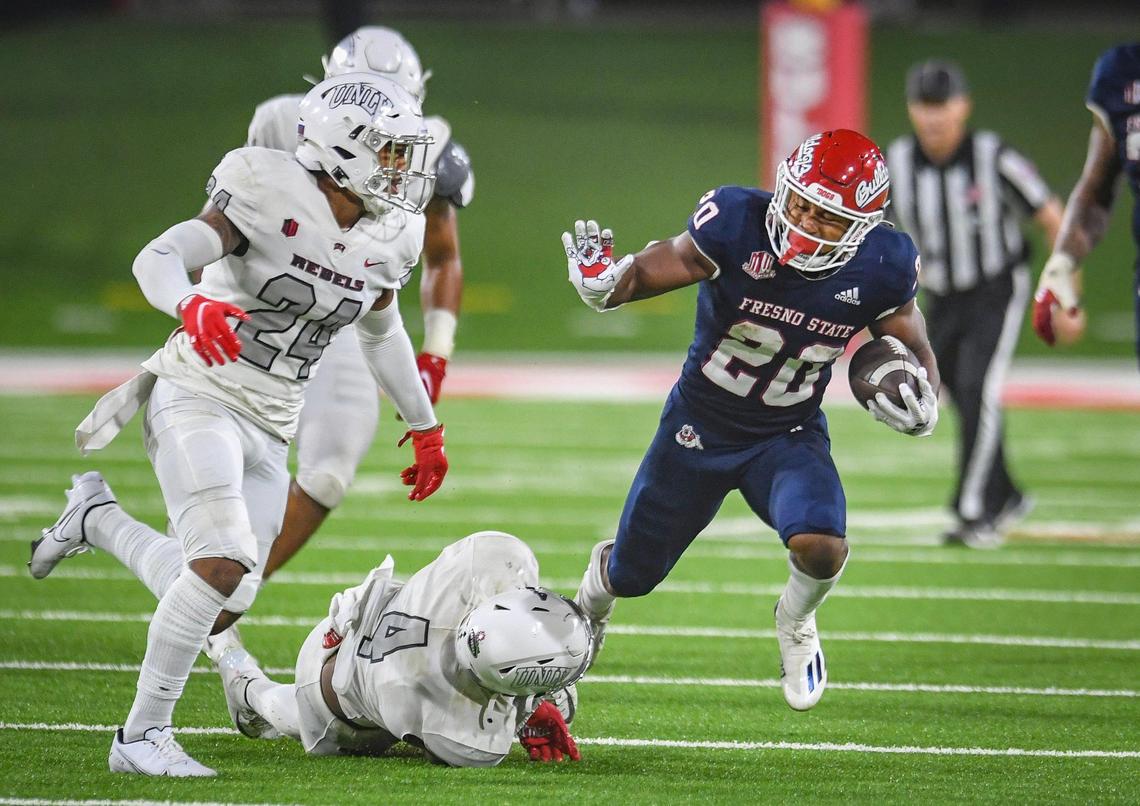 Fresno State’s Ronnie Rivers, right, gets tripped up by UNLV’s Jacoby Windmon on a run play during their game at Bulldog Stadium on Friday, Sept. 24, 2021.