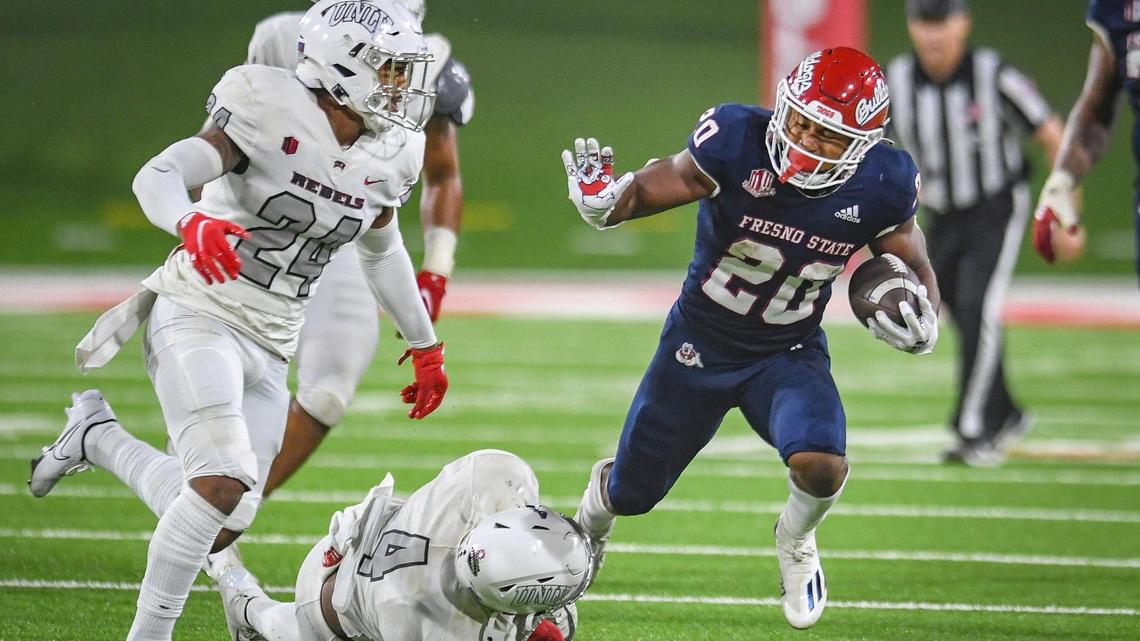 Fresno State’s Ronnie Rivers, right, gets tripped up by UNLV’s Jacoby Windmon on a run play during their game at Bulldog Stadium on Friday, Sept. 24, 2021.