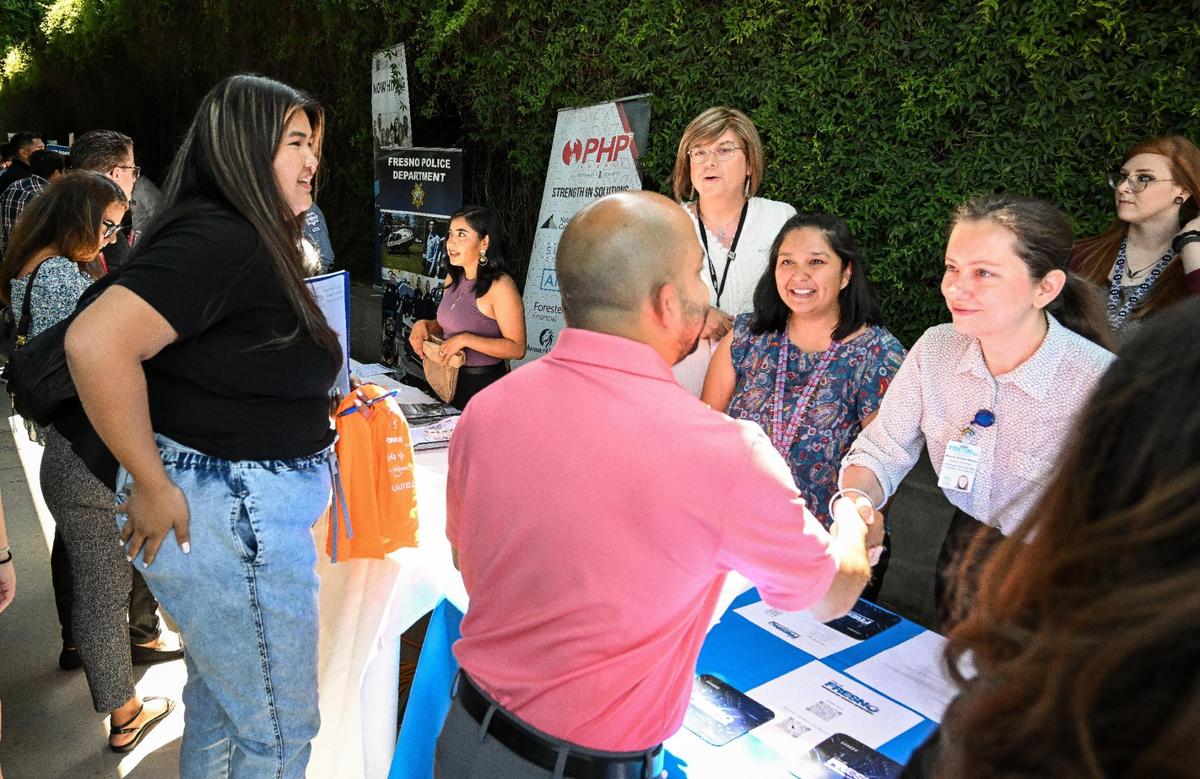 Job-seekers stop to speak to City of Fresno recruiters who were among dozens of area businesses and government agencies looking to hire during a job fair hosted by Workforce Connection and the City of Fresno in response to the laying off of 300 Fresno employees from Bitwise Industries, at Fresno City Hall on Friday, June 16. 2023.