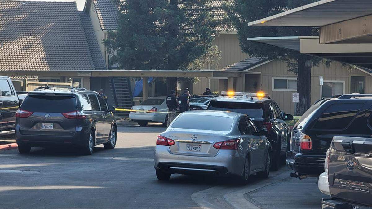 Police tape off an apartment complex as they make announcements to anyone inside the unit to come out after a shooting on Friday, Oct. 1, 2021.