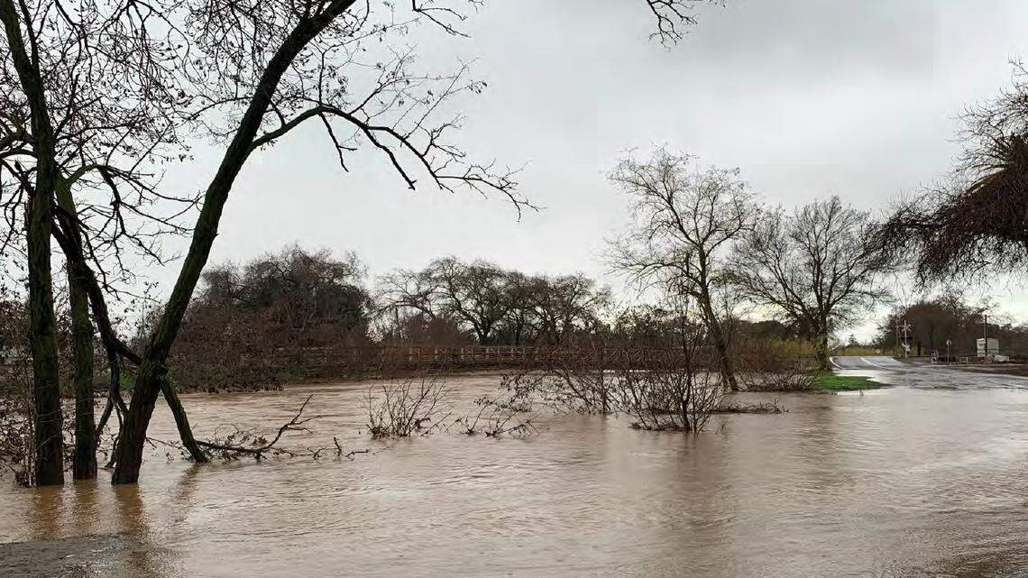 Bear Creek overflowed its banks near the 25th Street Bridge in western Merced, spilling over onto nearby West North Bear Creek Drive (under water at right) as a result of high flow after a major storm Jan. 9 and 10, 2023.