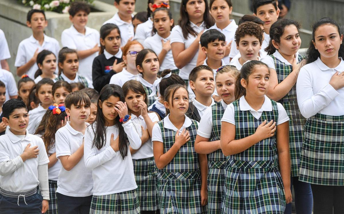 Students from the Charlie Keyan Armenian Community School in Clovis salute during the Armenian flag raising at the annual Armenian genocide commemoration and flag raising ceremony at Fresno City Hall on Friday, April 22, 2022.