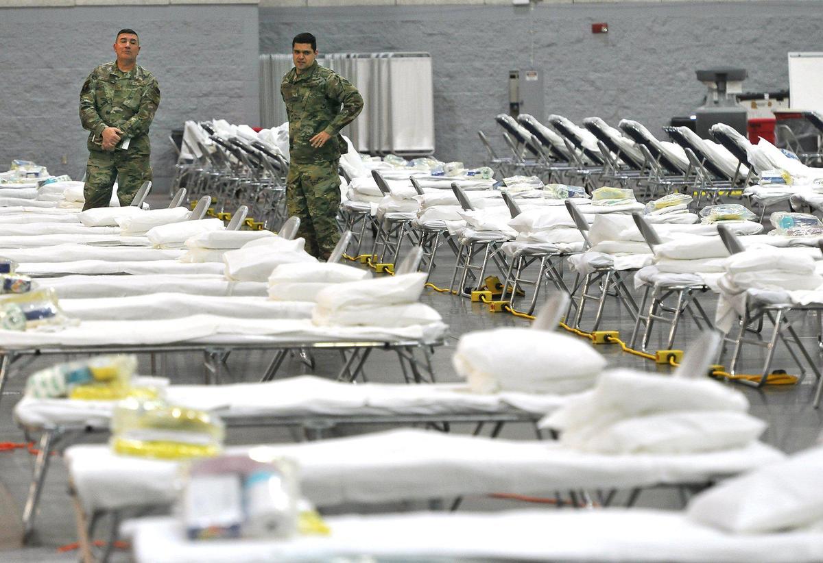 Senior Master Sergeant Matt Drudge, left, and Capt. Jason Sanchez, both of the 144th Fighter Wing of the California Air National Guard, look over the Alternative Care Facility set up with 265 cots and medical supply kits at the Fresno Convention Center, Exhibit Hall, Thursday April 9, 2020. The facility was set up in 5 and 1/2 hours by 9 members of the 144th, and 30 of the 146th Air Lift Wing of the Air National Guard from Ventura