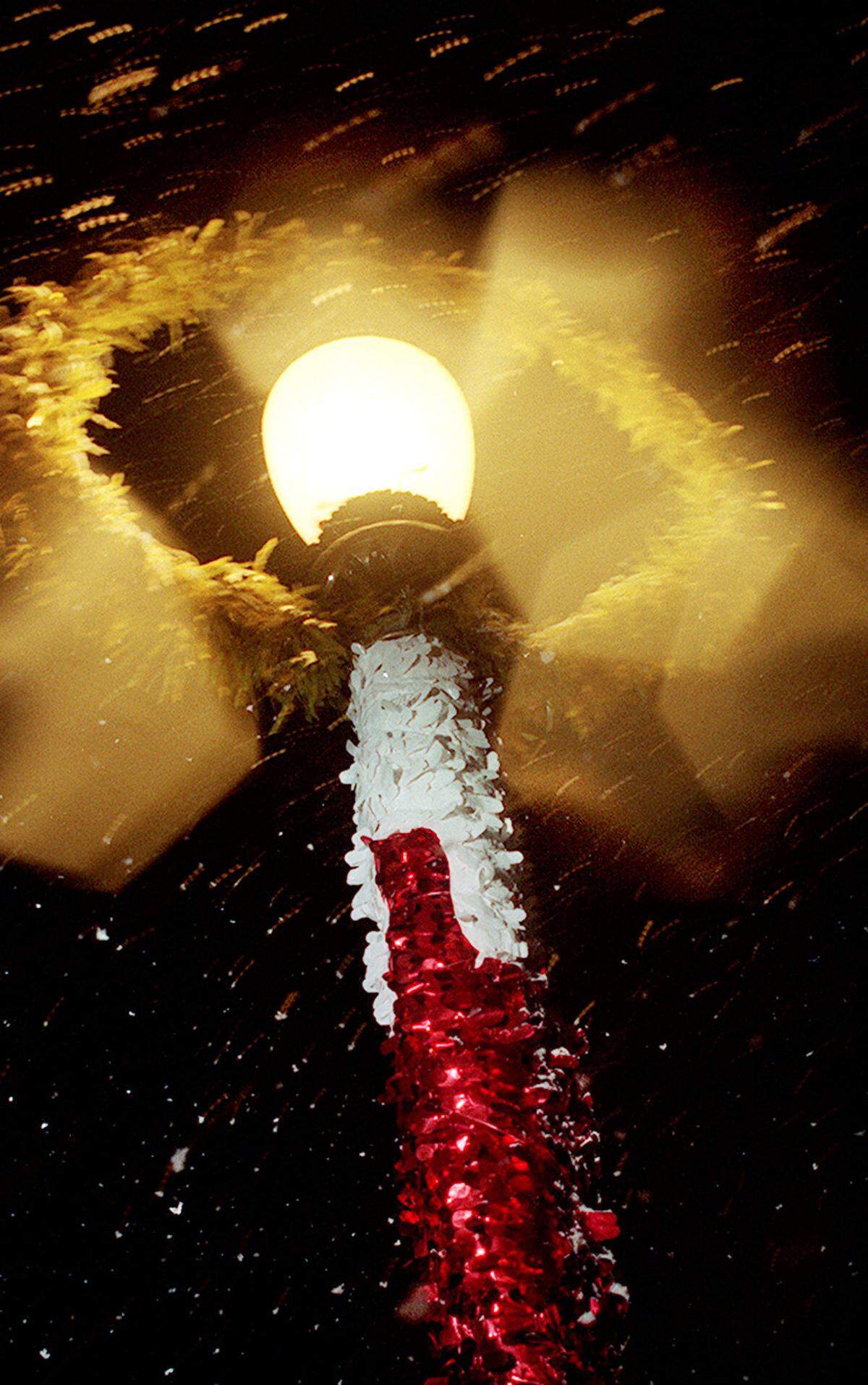 Snowflakes are caught in the light of a streetlamp along Huntington Boulevard during an unusual snow fall on Sunday night, Dec. 20, 1998, in Fresno.