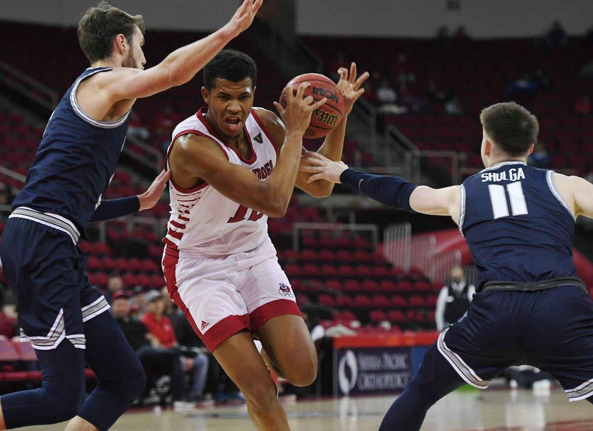 Fresno State’s Orlando Robinson, center, is covered by Utah State’s Brandon Horvath, left, and Max Shulga, right, in first period action Tuesday night, Jan. 18, 2022 in Fresno. Utah led Fresno State 31-21.
