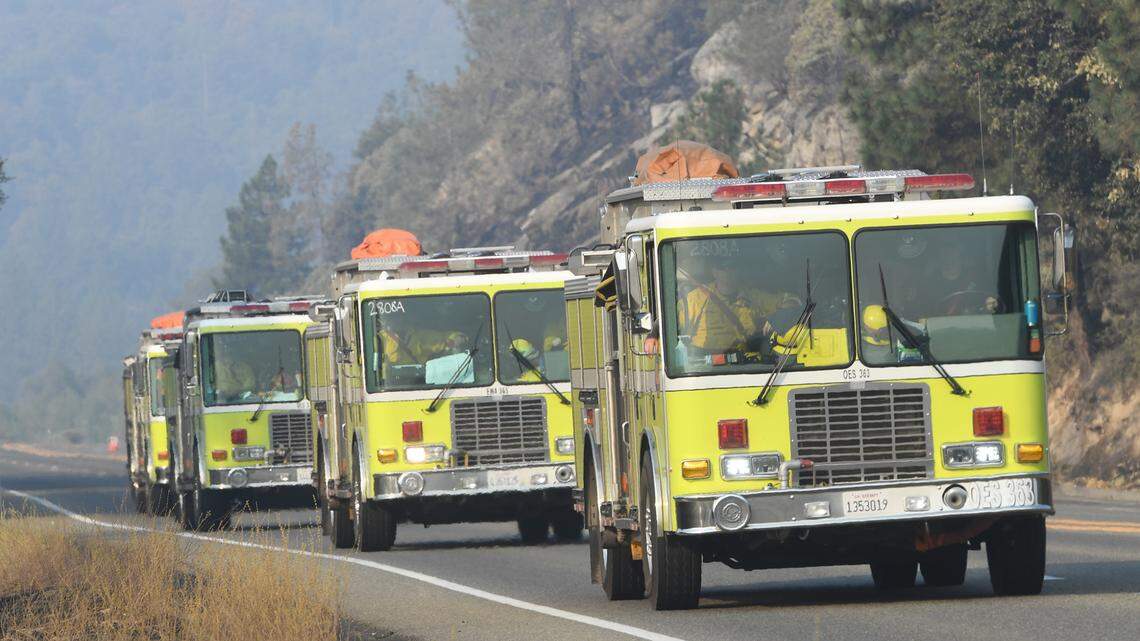 A line of fire trucks head up Highway 168 below Shaver Lake on Monday morning, Sept. 21, 2020, as work continues on containing the Creek Fire.