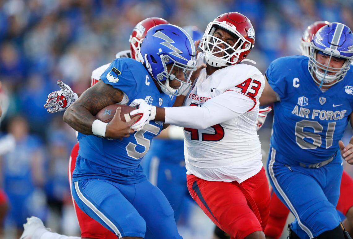 Fresno State defensive tackle Alex Dumais, right, takes down Air Force quarterback Donald Hammond III in a loss at Air Force last season. The Bulldogs have scheduled a guarantee games at Michigan in 2024 and at USC in 2028 as well as a home-ahd-home series with Georgia Southern with games in 2025 and ’28.
