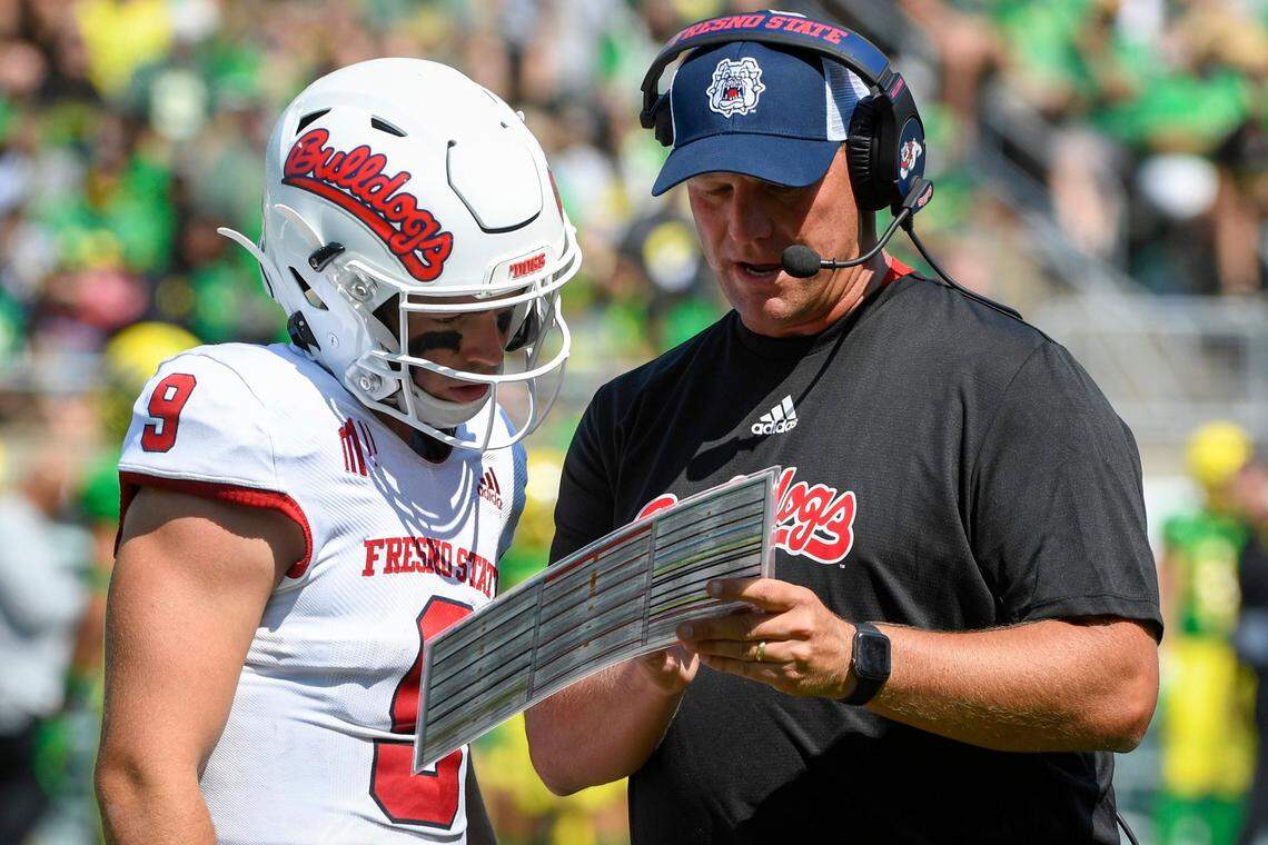 Fresno State quarterback Jake Haener talks with coach Kalen DeBoer during the third quarter of the Bulldogs’ 31-24 loss at Oregon. This week, the Bulldogs are plotting their chances for the Mountain West championship game.