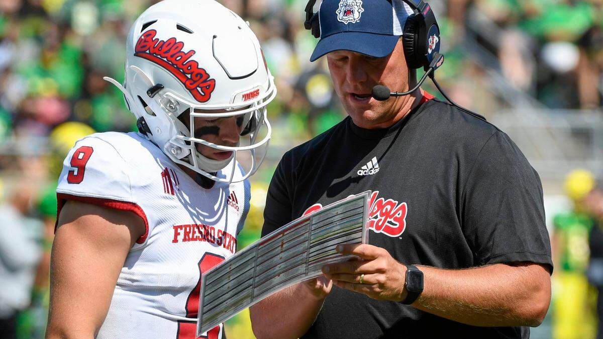 Fresno State quarterback Jake Haener talks with coach Kalen DeBoer during the third quarter of the Bulldogs’ 31-24 loss at Oregon. This week, the Bulldogs are plotting their chances for the Mountain West championship game.
