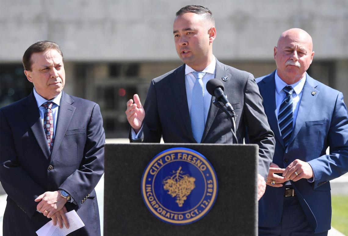 Fresno City Attorney Andrew Janz, center, with councilmember Garry Bredefeld, and Mayor Jerry Dyer, right, answers a question from the media about a proposed ordinance to go before the city council that would fine those who attend and watch as well as participate in any street racing, sideshow or other driving they called reckless, during a press conference in front of Fresno City Hall Wednesday, April 19, 2023 in Fresno. .