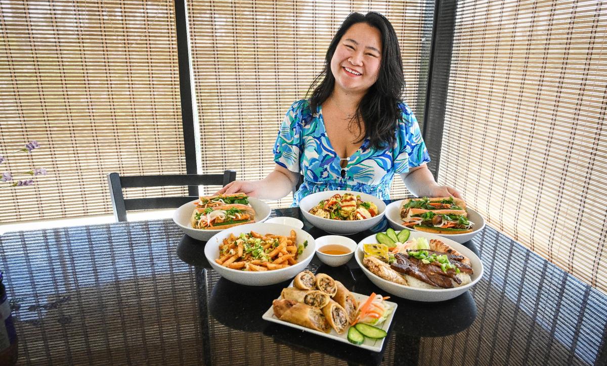 Leila Jace, owner of Sizzle n’ Steam in central Fresno, sits with several of the restaurant’s more popular Vietnamese dishes that reflect her upbringing in this Fresno Bee file photo.