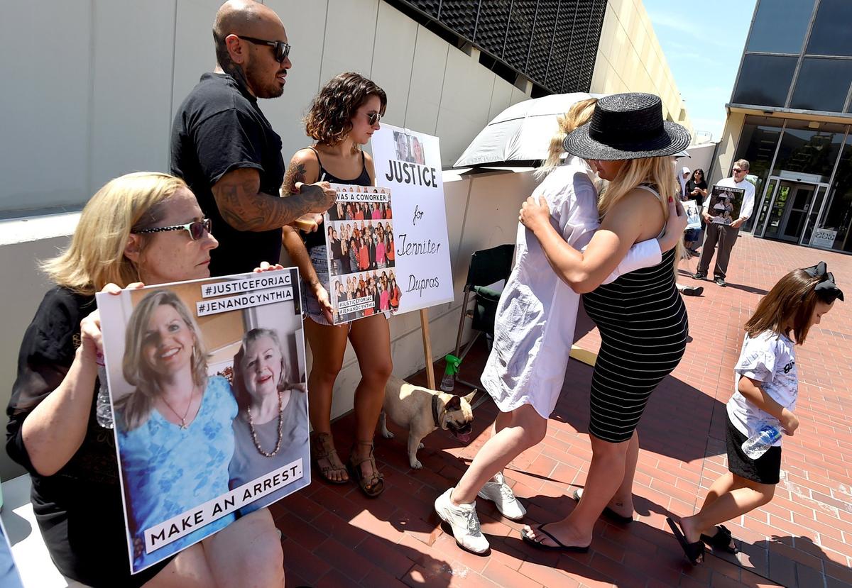 Alison Dupras, center in white, daughter of Jennifer Dupras and granddaughter of Cynthia Houk, who were killed in December, is hugged by friend Jordan Gustafson, during a silent protest with family and friends outside the Fresno County District Attorney’s office, Monday morning, July 23, 2018.
