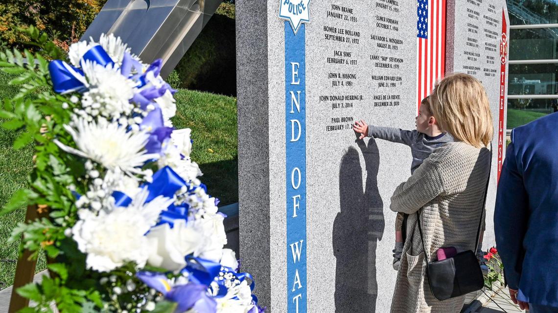 Family members take a close look at the names inscribed on the new First Responders Memorial honoring city police officers and firefighters who lost their lives after an unveiling ceremony outside Fresno City Hall on Wednesday, Nov. 2, 2022.