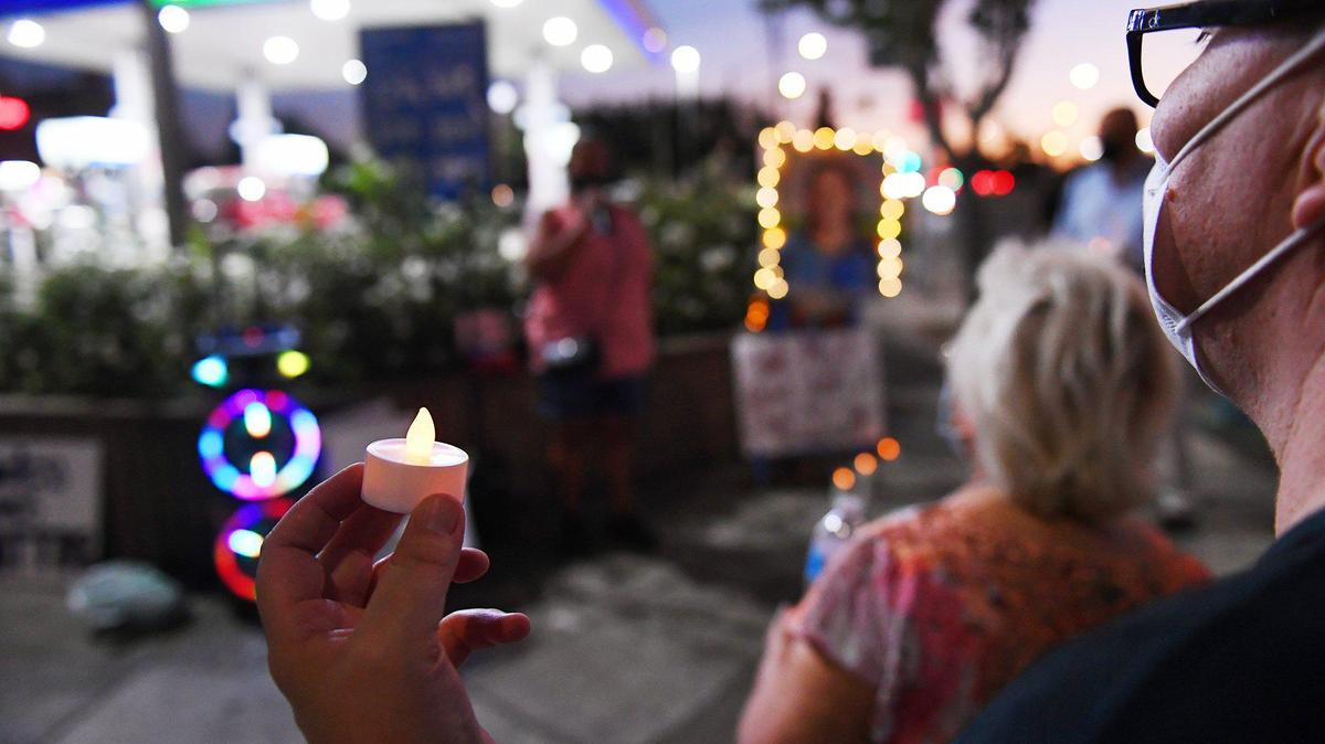 Jessica Mahoney, right, holds a candle during a vigil for Jose Valencia Pulido Friday evening, Sept. 25, 2020 at the corner of E Street and Fresno Street. Pulido was killed Sept 5 after being reportedly struck by a car driven by an on-duty Fresno Police detective.