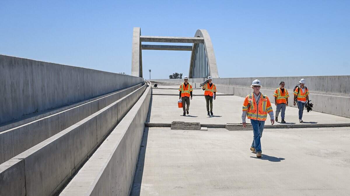 California High-Speed Rail team members walk across the nearly completed San Joaquin River viaduct section of the rail system near Highway 99 between Fresno County and Madera County on Wednesday, June 17, 2026. Cables, tracks and other infrastructure are soon to come, say authorities.