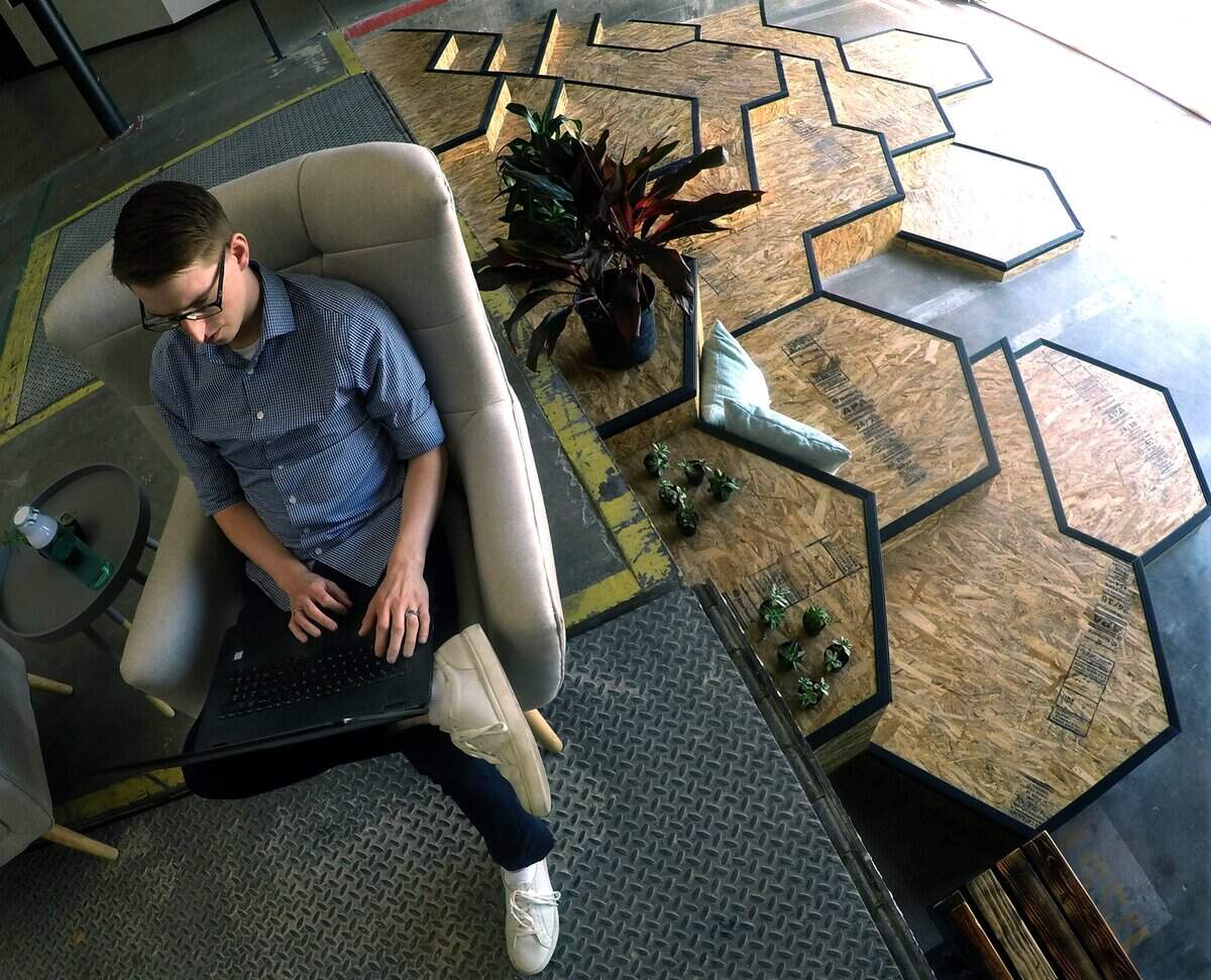 Next to a stairs in the shape of bee hives, Andrew Petwhoud of Ordrslip works in the lobby of the Bitwise Hive at 2600 Ventura St., Tuesday morning, May 29, 2018.