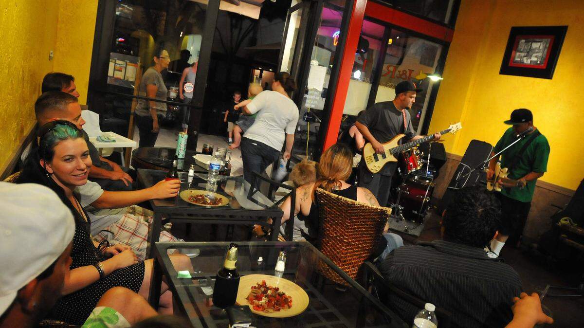 Customers listen to local band Homebrew as they enjoy food and drinks at J&R Taco late Saturday night.