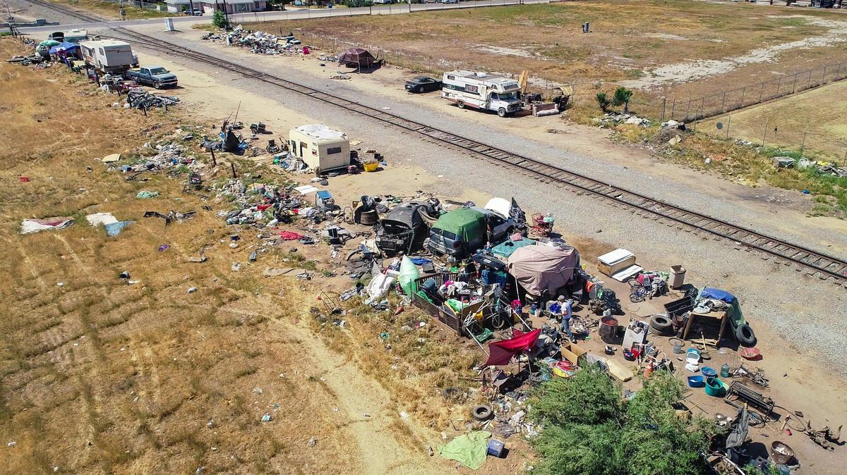 A homeless encampment lines the San Joaquin Valley Railroad right of way near Belmont and Brawley avenues, in an unincorporated area of Fresno County just outside the Fresno city limits in this 2021 file photo. A new county ordinance approved on Aug. 20, 2024, forbids camping on public property including sidewalks, as well as along railroads or rail yards.