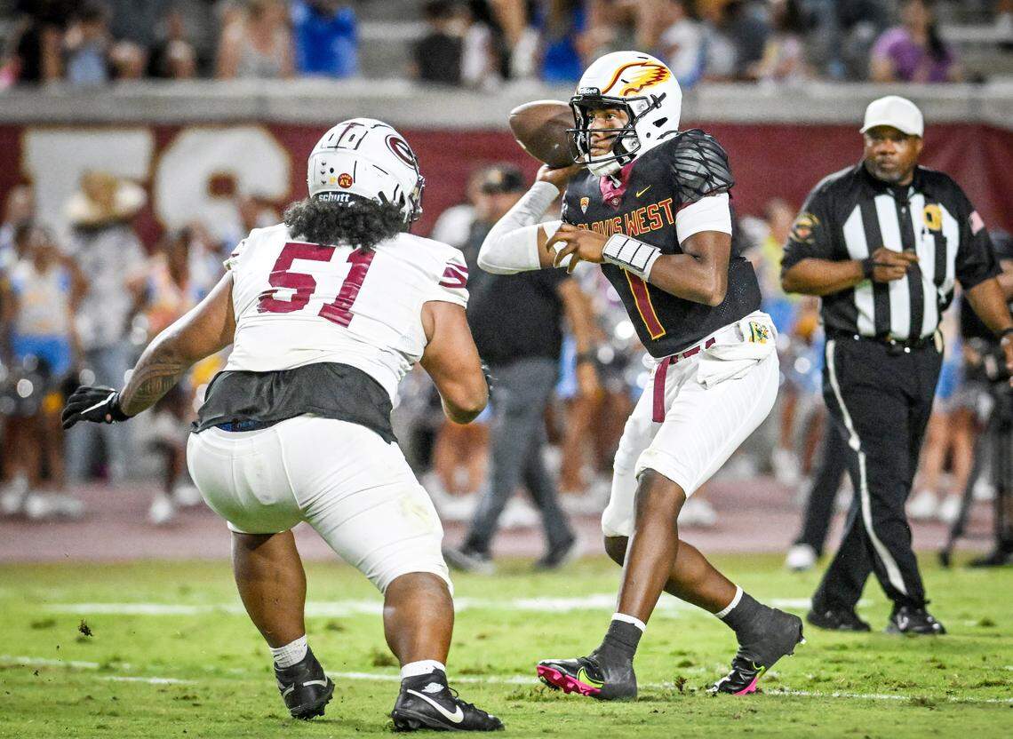 Clovis West quarterback Jamar (JJ) Howard, right, looks to throw while getting pressure from an Edison defender in the first half of their game at Veterans Memorial Stadium in Clovis on Friday, Sept. 5, 2025.
