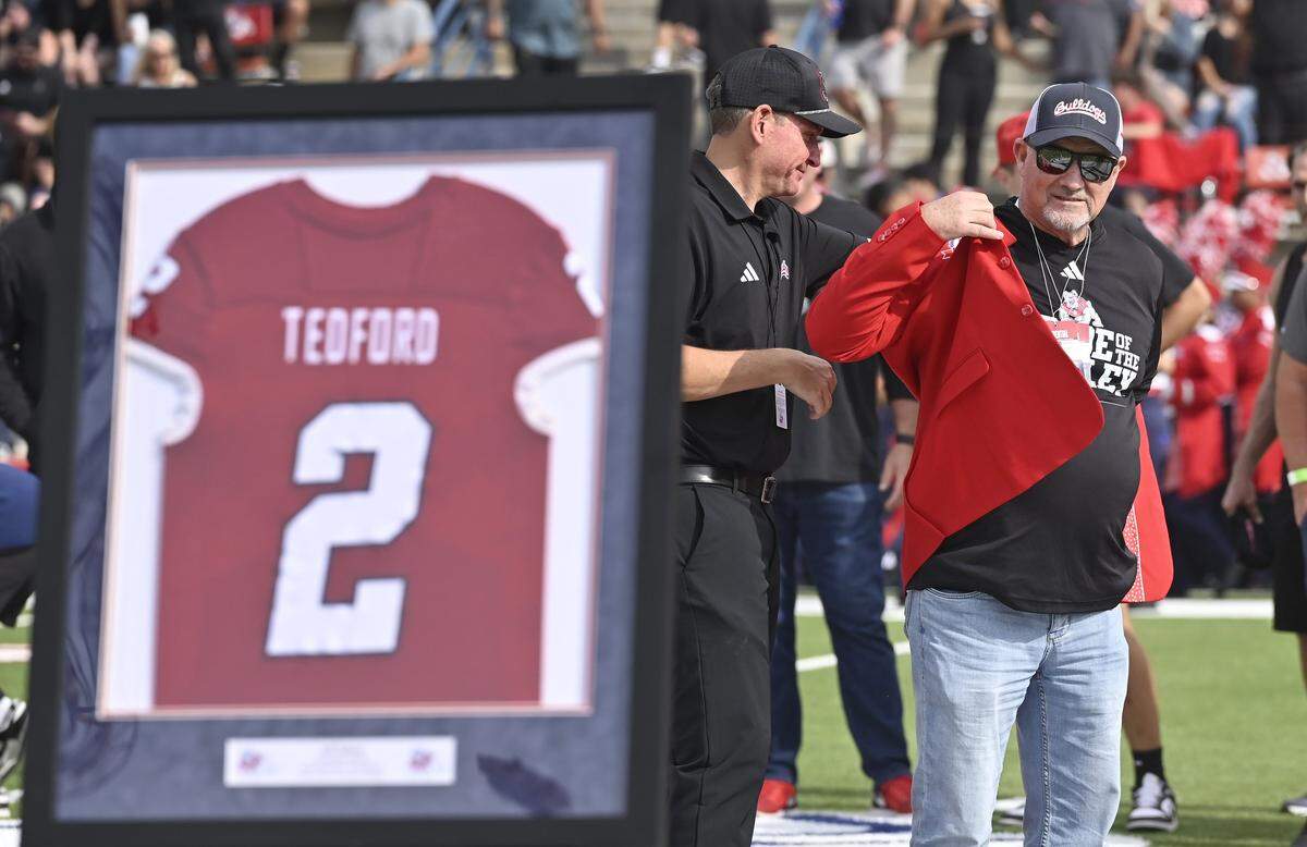 Former Fresno State football head coach Jeff Tedford pulls on a red blazer as he's honored during haftime Saturday, Oct. 24, 2025 in Fresno. 