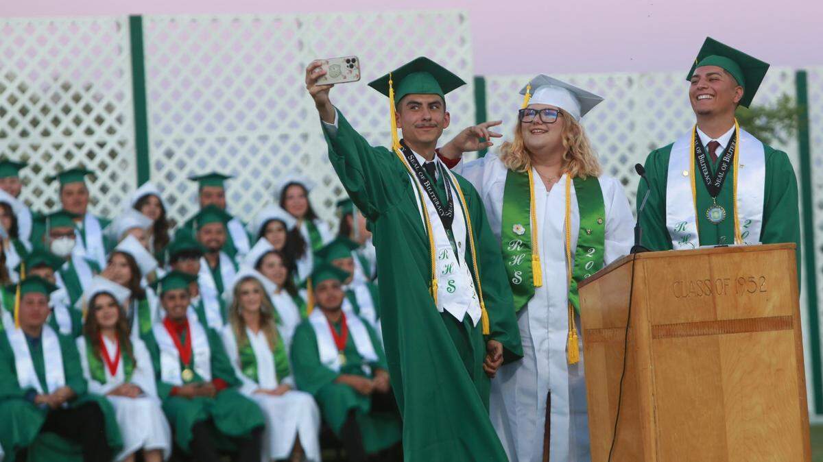 Riverdale High School class salutatorians Giovanni Roa, left, Leona Phillips, center, and Iván Ibarra, right, take a class selfie during the graduation ceremony Friday night (June 10) at Cowboys Stadium Jack King Field.