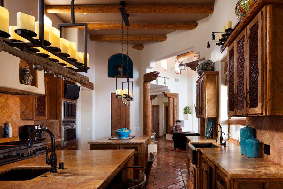 The chef’s kitchen features travertine counters, a Wolf range with six burners, three ovens, a warming drawer, Subzero fridge, dual copper sinks, a mini wine fridge, ice maker and two pantries.