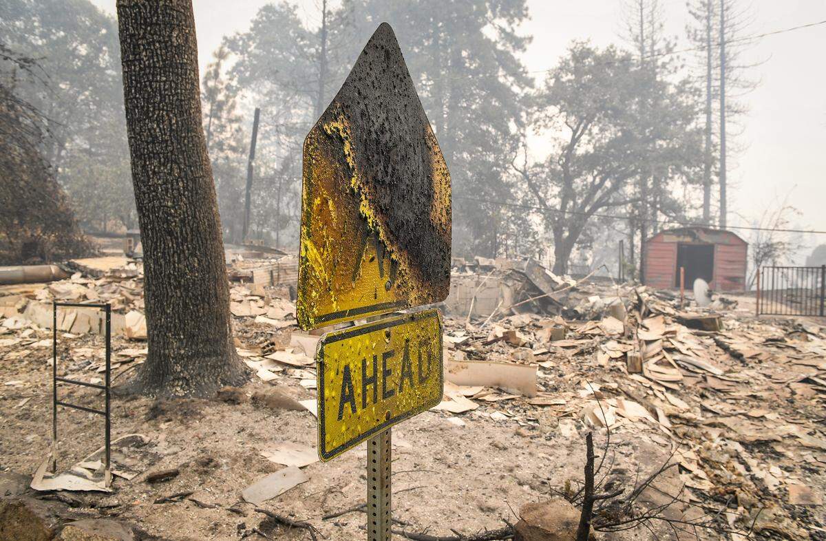 A charred road sign stands in front of a destroyed home in Big Creek on Monday, Sept. 7, 2020 after the Creek Fire burned through the area over the weekend. Although several homes were destroyed, the general store, the school and several other buildings appear undamaged.