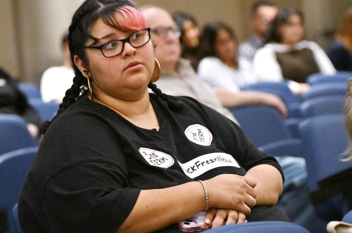 Krista Aranda with stickers against a third term for Mayor Jerry Dyer listens closely during a Fresno City Council meeting Thursday, July 30, 2026 in downtown Fresno.