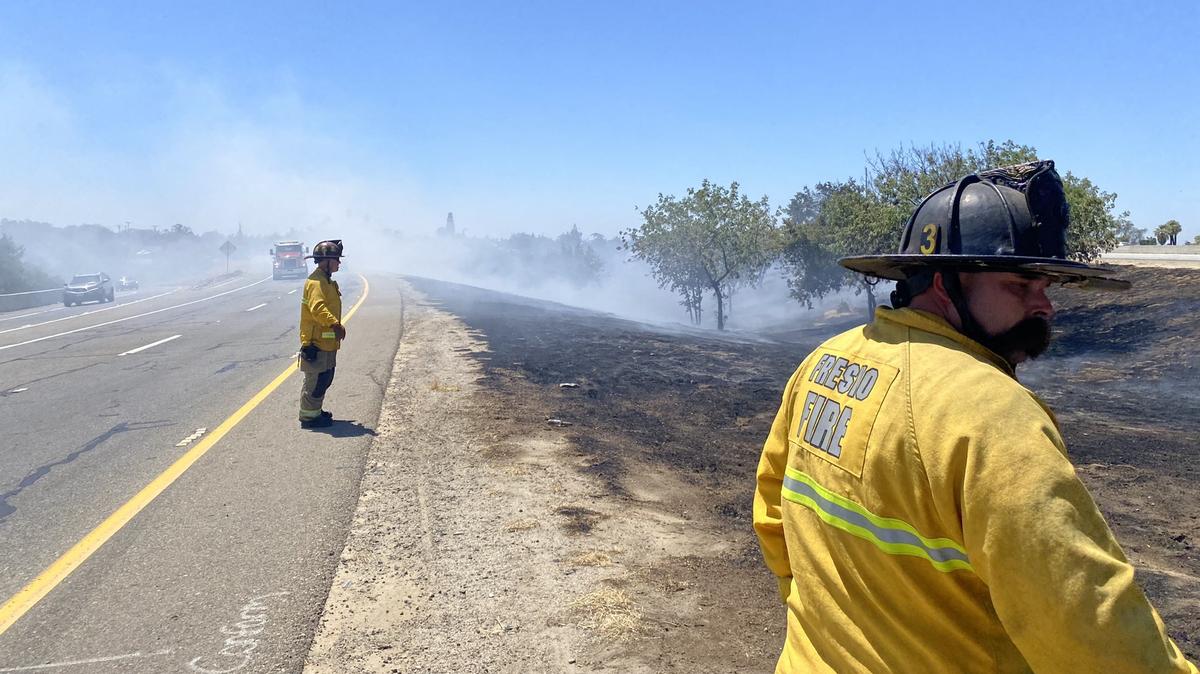 Firefighters clean up a fire near the Highway 99 and Highway 180 interchange in Fresno, California, on Thursday, Aug. 11, 2022.