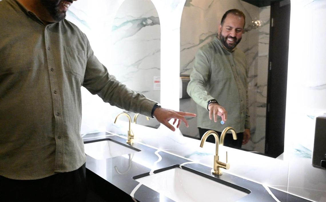 Rajan Bisla demonstrates the variable lighting touch button in the new women’s restroom at The Standard. The bar and restaurant has been remodeled with changes to the menu and interior decor.